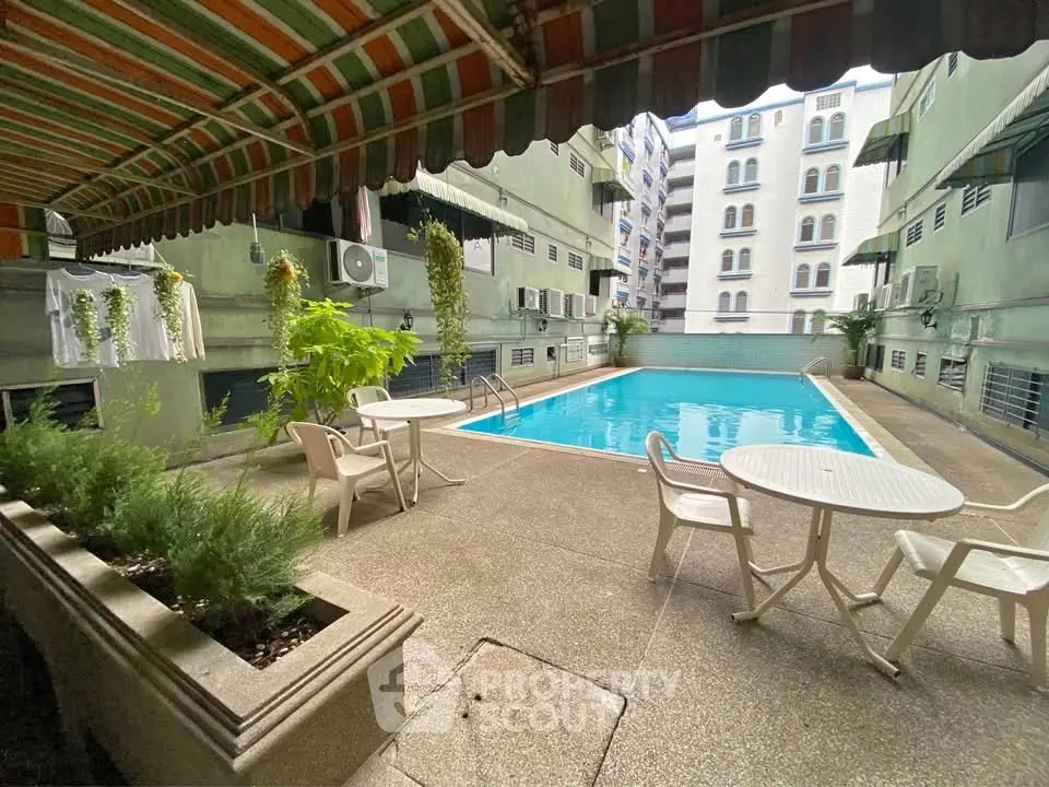 Inviting residential pool area with seating and greenery, perfect for relaxation and leisure.