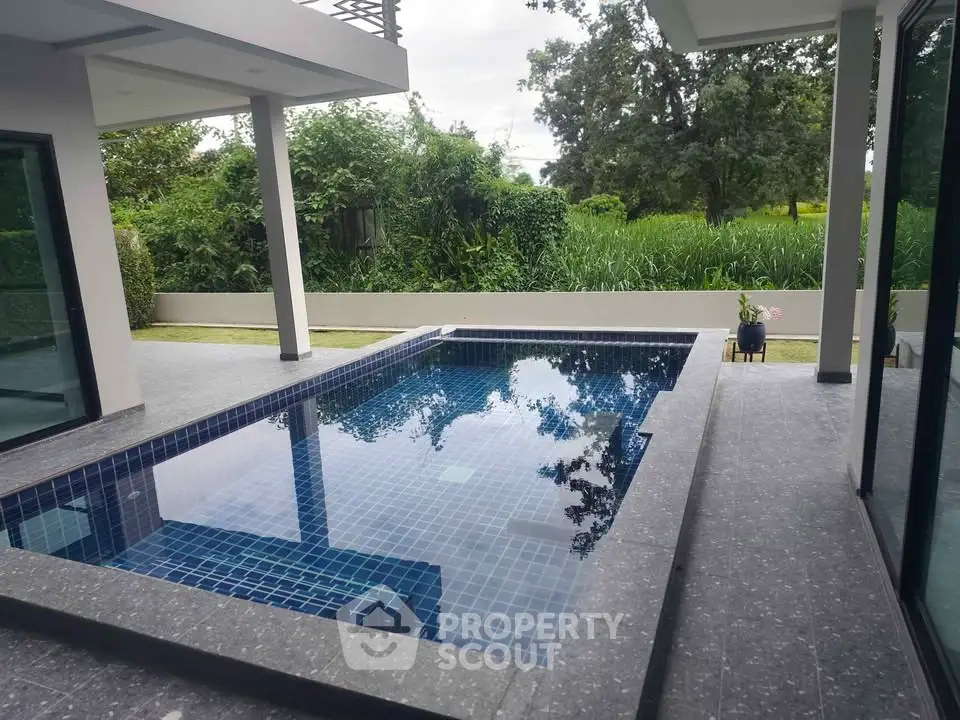 Luxurious modern home with private pool and lush greenery view, perfect for relaxation and entertainment.