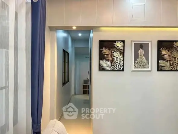 Stylish hallway with elegant artwork and modern lighting in a contemporary home.