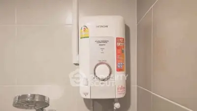Modern bathroom with electronic water heater and sleek shower head.
