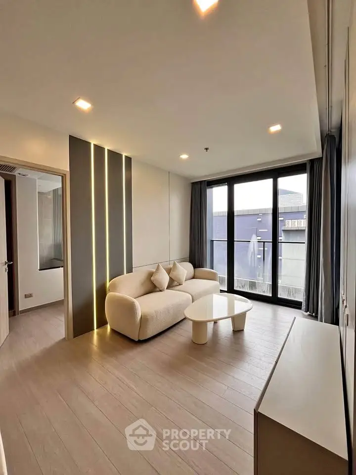 Modern living room with elegant lighting and large windows in a stylish apartment.