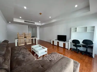 Spacious living room with modern furniture and wooden flooring, ideal for family gatherings.