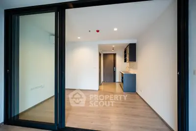 Modern open-plan living area with sleek kitchen and sliding glass doors in a contemporary apartment.