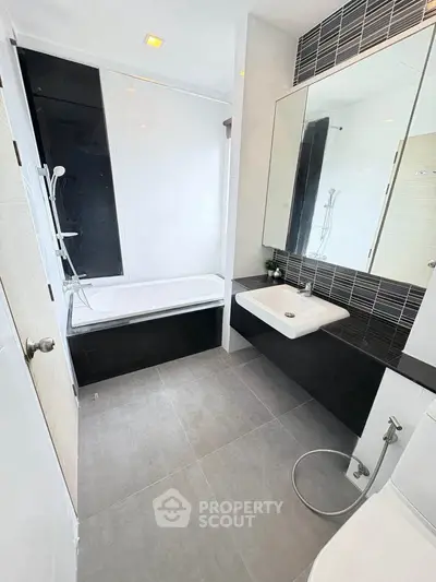 Modern bathroom with sleek design, featuring a bathtub and stylish fixtures.