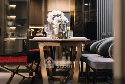 Elegantly set dining table with modern chairs in a luxurious open-plan living space, featuring high-end finishes and warm lighting.