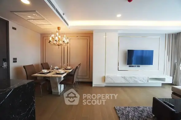 Luxurious modern living room with elegant dining area and wall-mounted TV, featuring chic lighting and stylish decor.