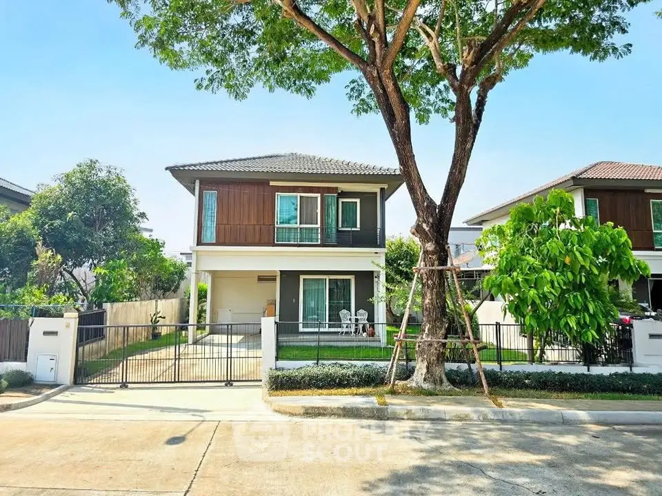 Charming two-story house with lush garden and spacious driveway in serene neighborhood.