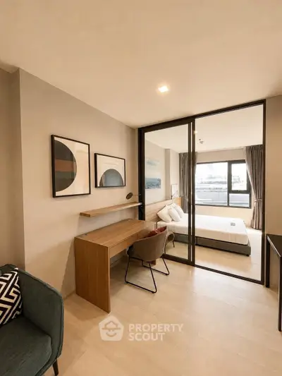 Modern bedroom with stylish decor and study area, featuring large windows and contemporary furniture.
