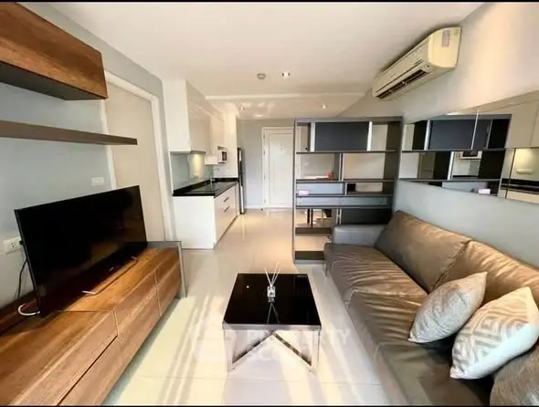 Modern living room with sleek furniture and open kitchen layout in stylish apartment.