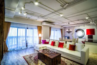 Spacious modern living room with stylish decor and large windows offering natural light.