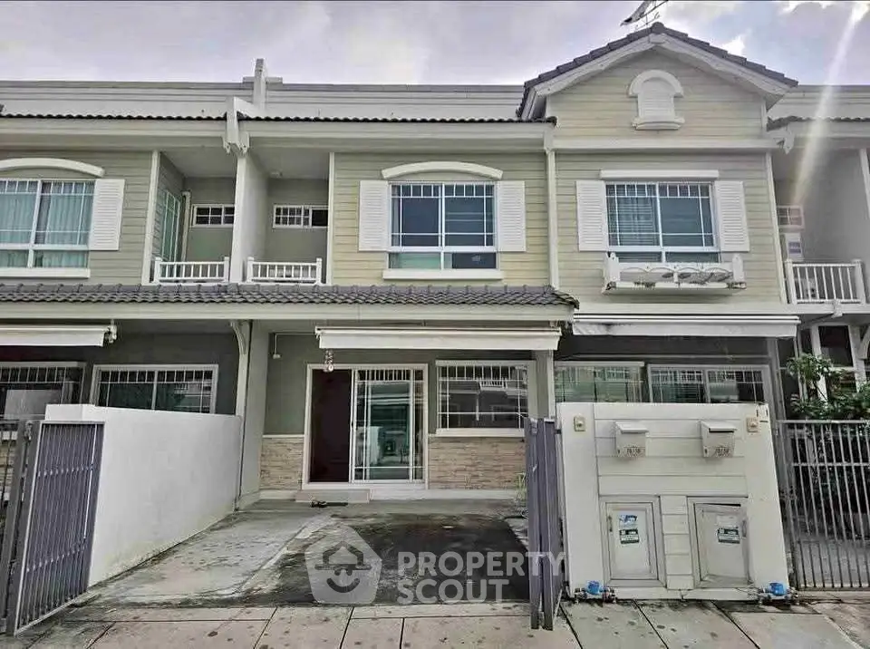 Charming two-story townhouse with modern facade and gated driveway