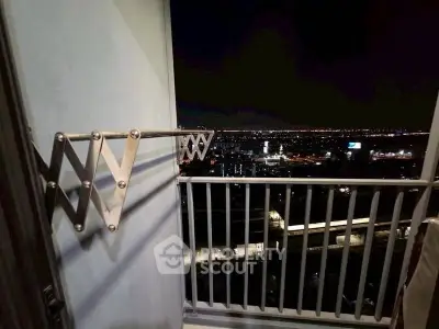 Stunning night cityscape view from a high-rise balcony with sleek railing design.