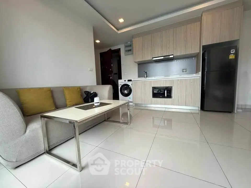 Modern open-plan living room with sleek kitchen and appliances