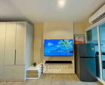 Modern living room with wall-mounted TV and sleek refrigerator in a stylish apartment.