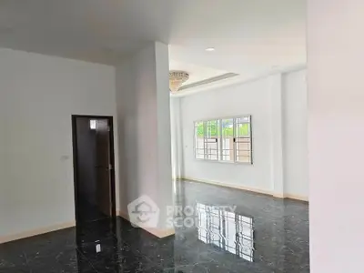 Spacious modern living room with glossy black marble floors and elegant chandelier.