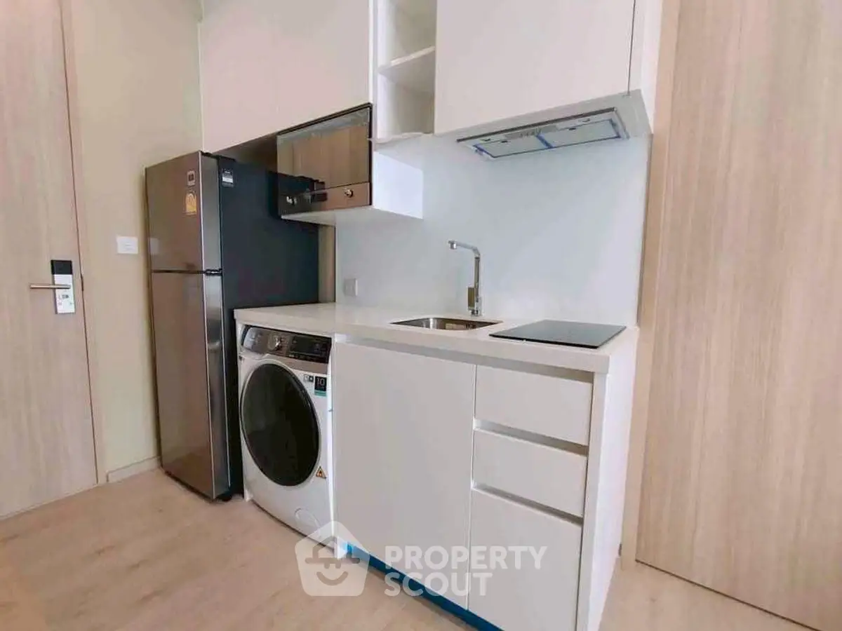Modern compact kitchen with integrated appliances and sleek cabinetry