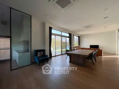 Spacious modern living room with large windows and elegant dining area