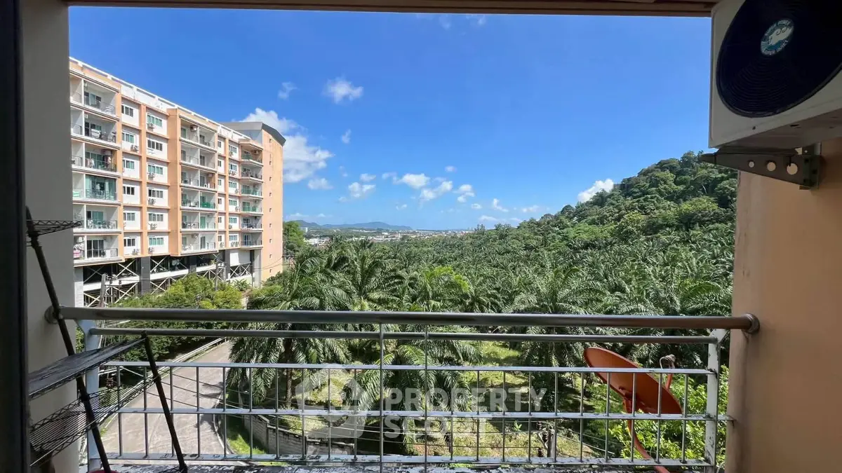 Scenic balcony view overlooking lush greenery and distant mountains, perfect for nature lovers.