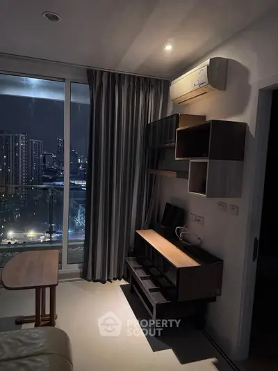 Modern living room with city view, stylish furniture, and air conditioning.