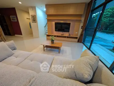 Spacious modern living room with cozy sofa and large TV, perfect for relaxation and entertainment.