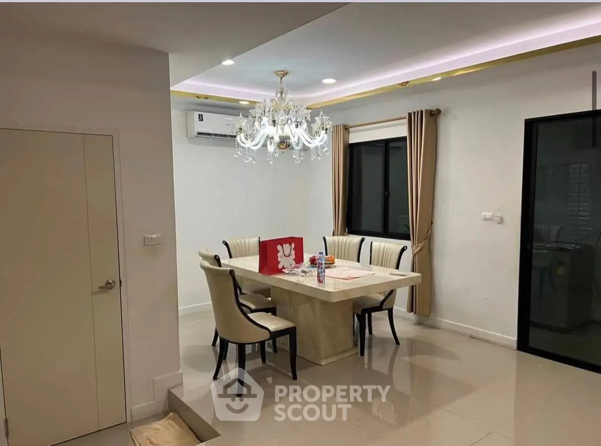 Elegant dining area with chandelier and modern furniture in a stylish home interior.