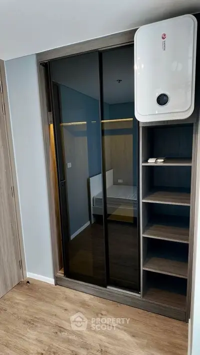 Modern bedroom with mirrored wardrobe and sleek wooden flooring
