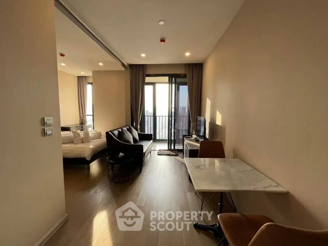 Modern apartment interior with open living area and bedroom, featuring stylish furniture and natural light.