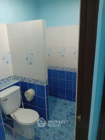 Charming blue-tiled bathroom with modern fixtures and nautical-themed accents.
