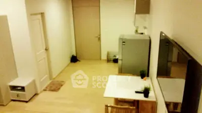 Cozy apartment interior with wooden flooring and modern furniture, featuring a compact kitchen area and stylish decor.