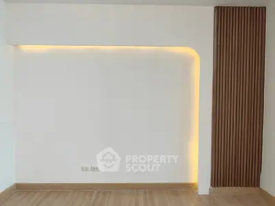 Modern minimalist interior wall with ambient lighting and wooden panel accent.