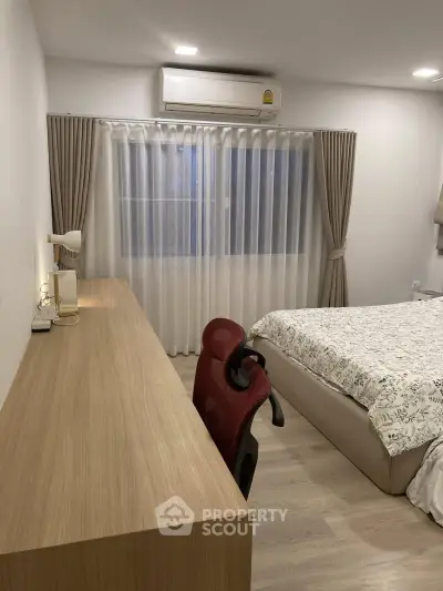 Modern bedroom with study area, featuring a sleek desk and comfortable chair, ideal for work-from-home setup.