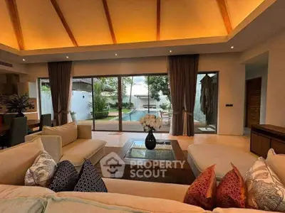 Luxurious living room with pool view, elegant decor, and cozy seating in a modern villa.