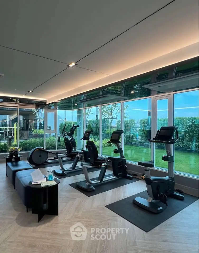 Modern gym with exercise bikes and large windows overlooking a garden, perfect for fitness enthusiasts.