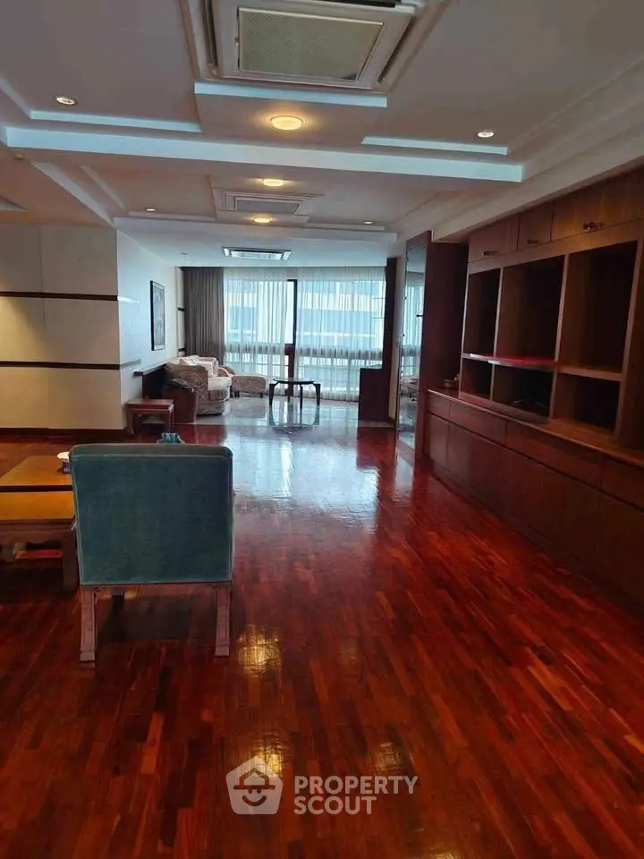 Spacious living room with polished wooden floors and elegant furniture, perfect for luxury living.