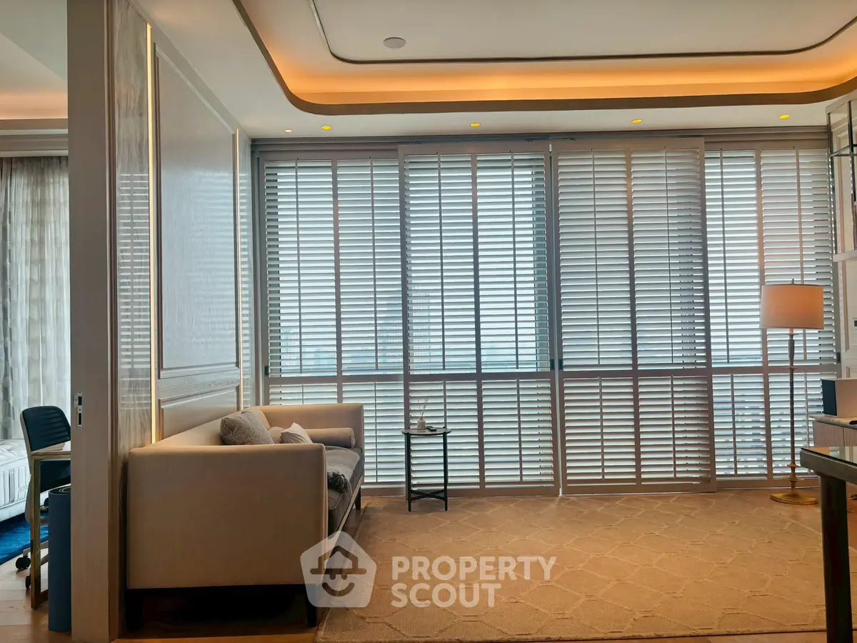 Luxurious living room with modern sofa and floor-to-ceiling windows with blinds.