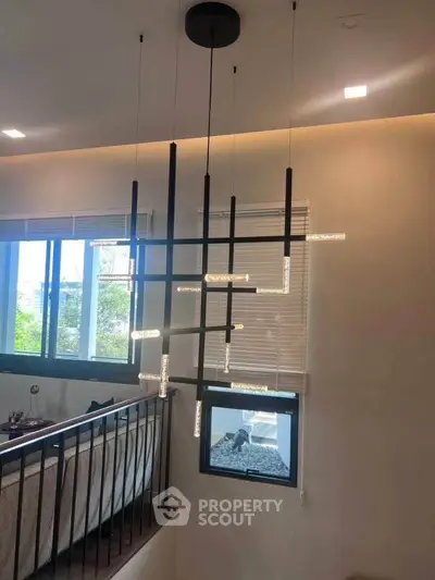 Modern interior with stylish chandelier and large windows in a contemporary home.