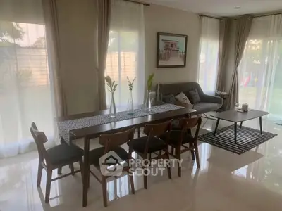 Elegant dining and living area with natural light and garden view.