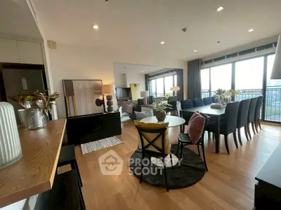 Spacious modern living room with dining area and large windows offering natural light.