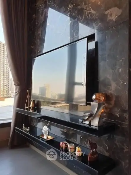 Luxurious living room with marble wall and large TV, offering a stunning city view.