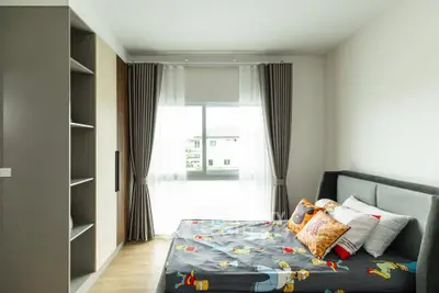 Cozy bedroom with modern decor and large window offering natural light