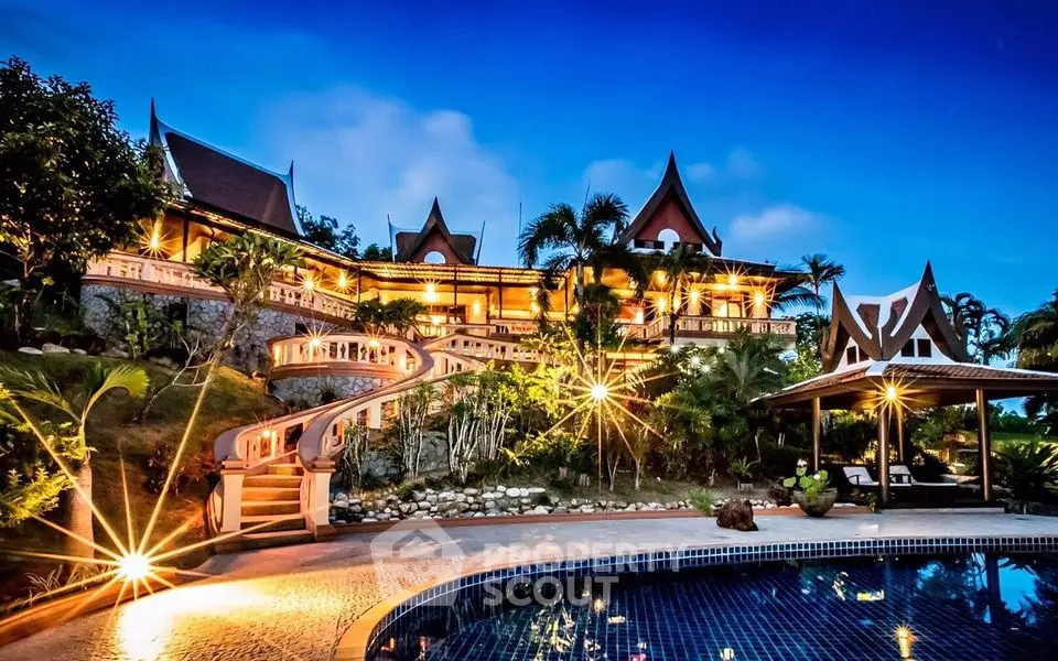 Luxurious Thai-style villa with stunning pool and lush garden at dusk.
