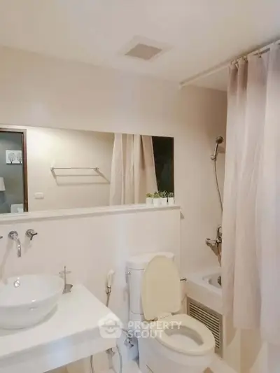 Modern bathroom with elegant fixtures and a cozy ambiance, featuring a bathtub and stylish sink.