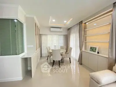 Elegant living room with modern decor and natural light, featuring a cozy dining area and stylish furnishings.