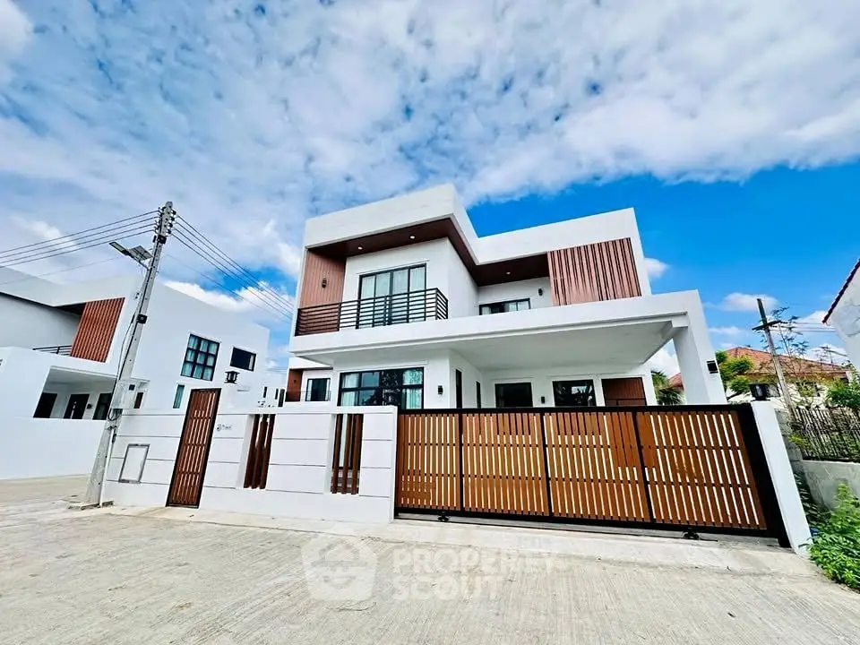 Modern two-story house with sleek design and wooden accents under a clear blue sky.