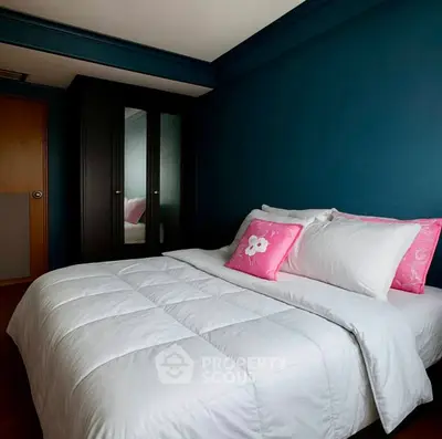 Cozy bedroom with dark blue walls and stylish decor, featuring a comfortable bed and mirrored wardrobe.