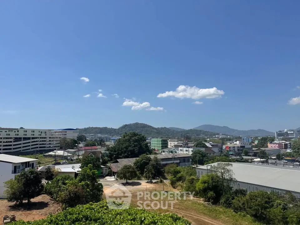 Scenic view of urban landscape with mountains and clear blue sky, ideal for real estate development.