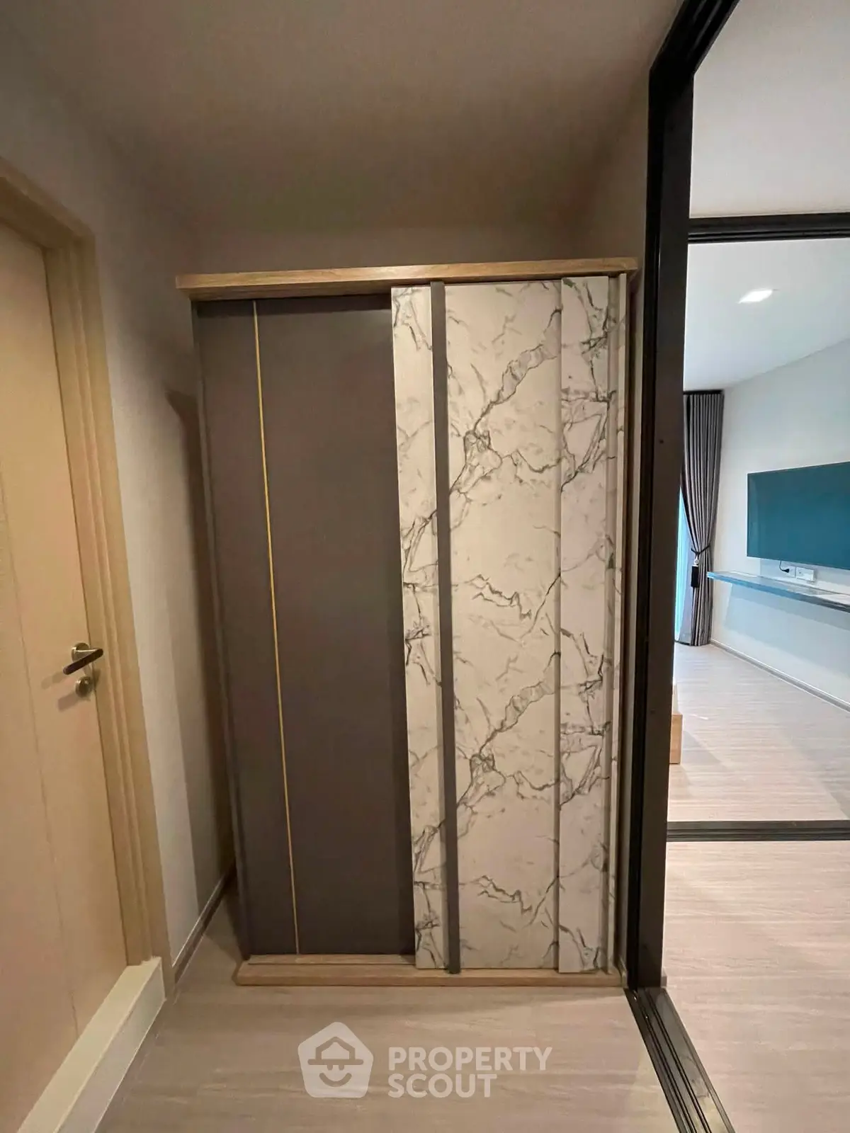 Modern interior with stylish sliding door and elegant marble design, leading to a spacious living area.