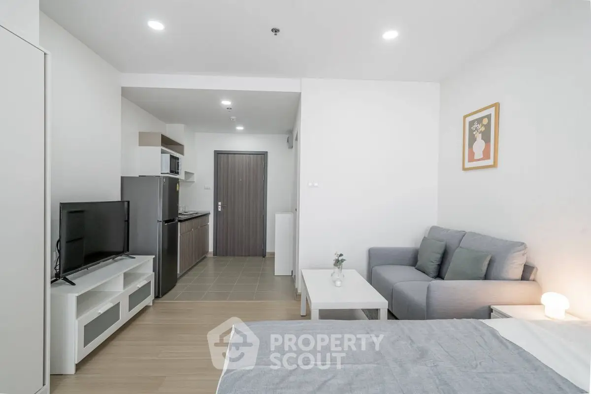 Modern studio apartment with cozy living area and compact kitchen