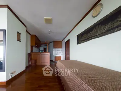 Spacious open-plan living area with wooden flooring and modern kitchen.