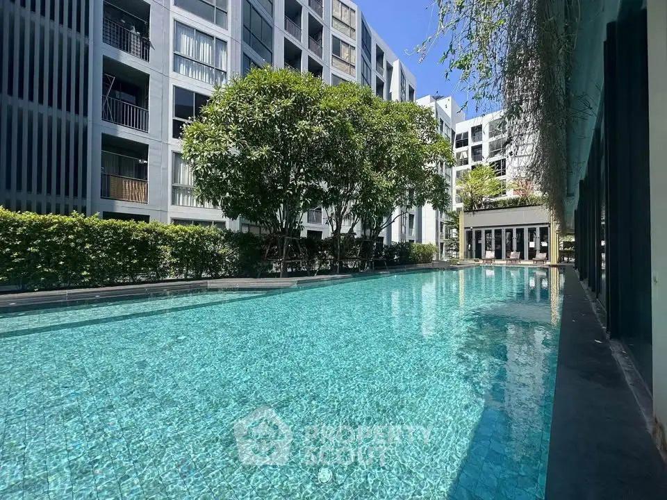 Luxurious apartment complex with sparkling pool and lush greenery